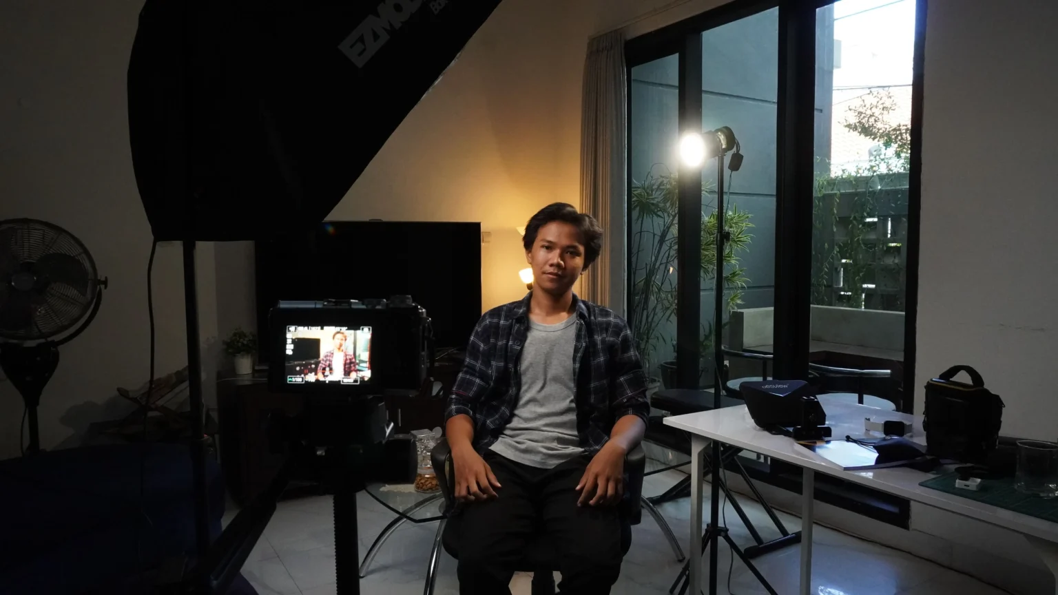 Seorang micro influencer sedang menyiapkan ring light di kamar untuk membuat konten, mewakili kreator dengan engagement rate tinggi
